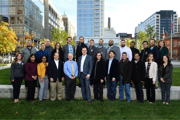 a professional group photo of twenty six team members