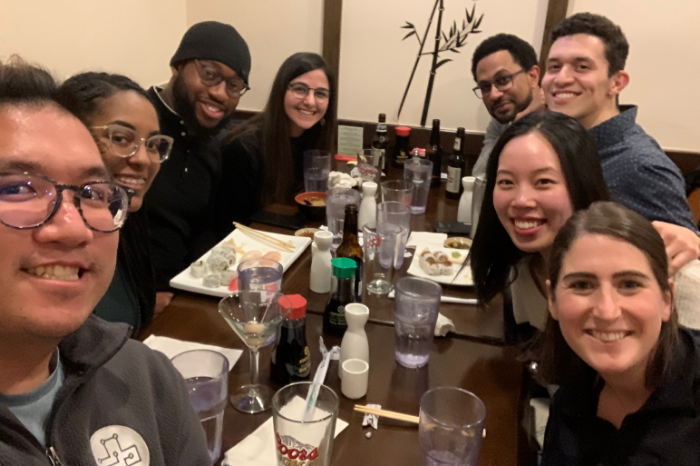 a group selfie during happy hour at a sushi restaurant